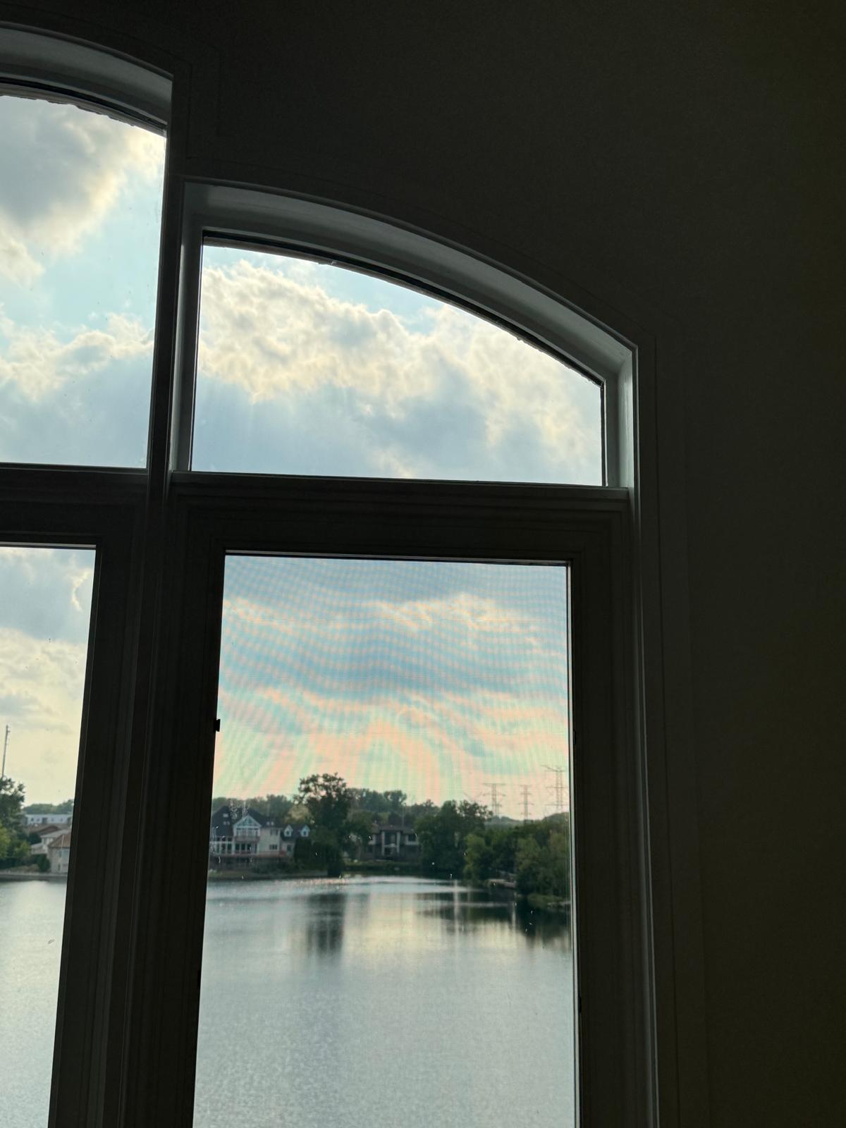 Interior view through arched windows overlooking a lake