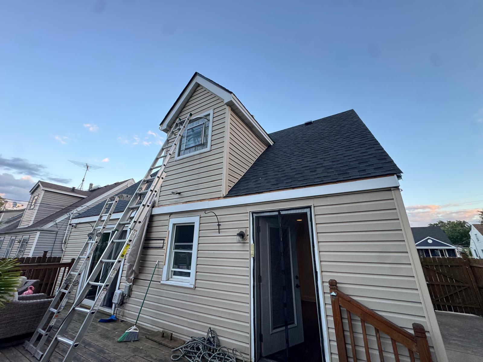 Exterior of a house with ladders positioned beside upper and lower windows